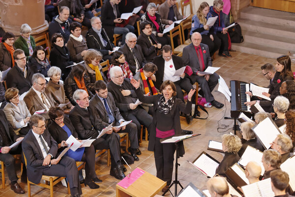 Sandra Rupp, Cantars-Gesamtleiterin, beim Dirigieren, links von ihr die Rednerin und die Redner am Festakt in Basel. © cantars 2015, Foto: André Albrecht.