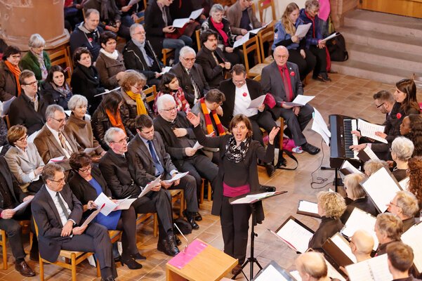 Sandra Rupp, Cantars-Gesamtleiterin, beim Dirigieren, links von ihr die Rednerin und die Redner am Festakt in Basel. © cantars 2015, Foto: André Albrecht.